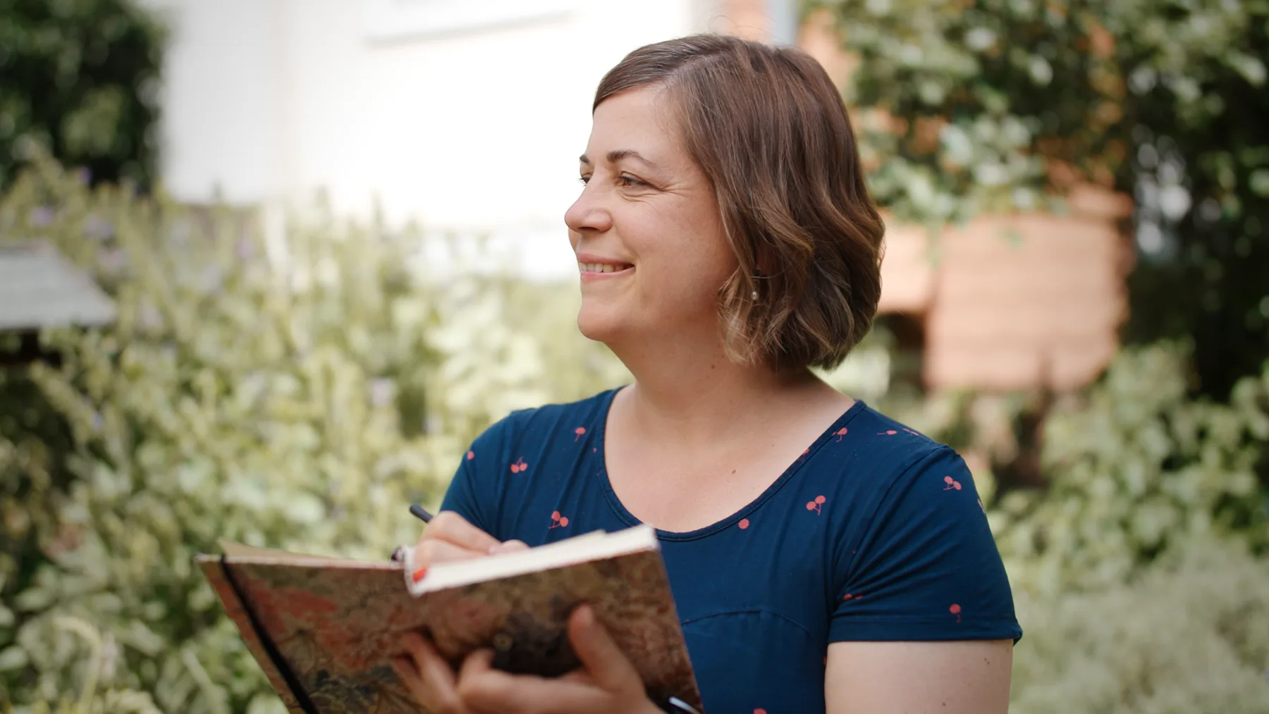 Kathy Pithan mit Notizbuch im Garten